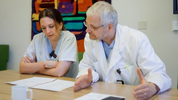 Neurologen och forskaren Karin Forsberg och överläkaren i neurologi och professorn Peter Andersen tittar igenom färska provsvar från ALS-patienten som deltagit i den aktuella genterapistudien.
