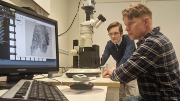 Doktoranden Joakim Lehrstrand och professor Ulf Ahlgren tittar på en bildskärm.