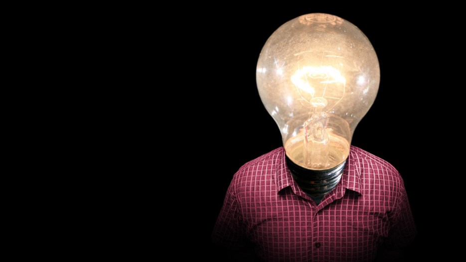 Manipulerad bild av en person i rutig skjorta med ett huvud som består av en tänd glödlampa