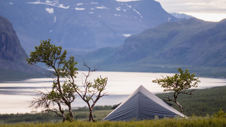 Tält i Sarek med sjö och fjäll i bakgrunden.