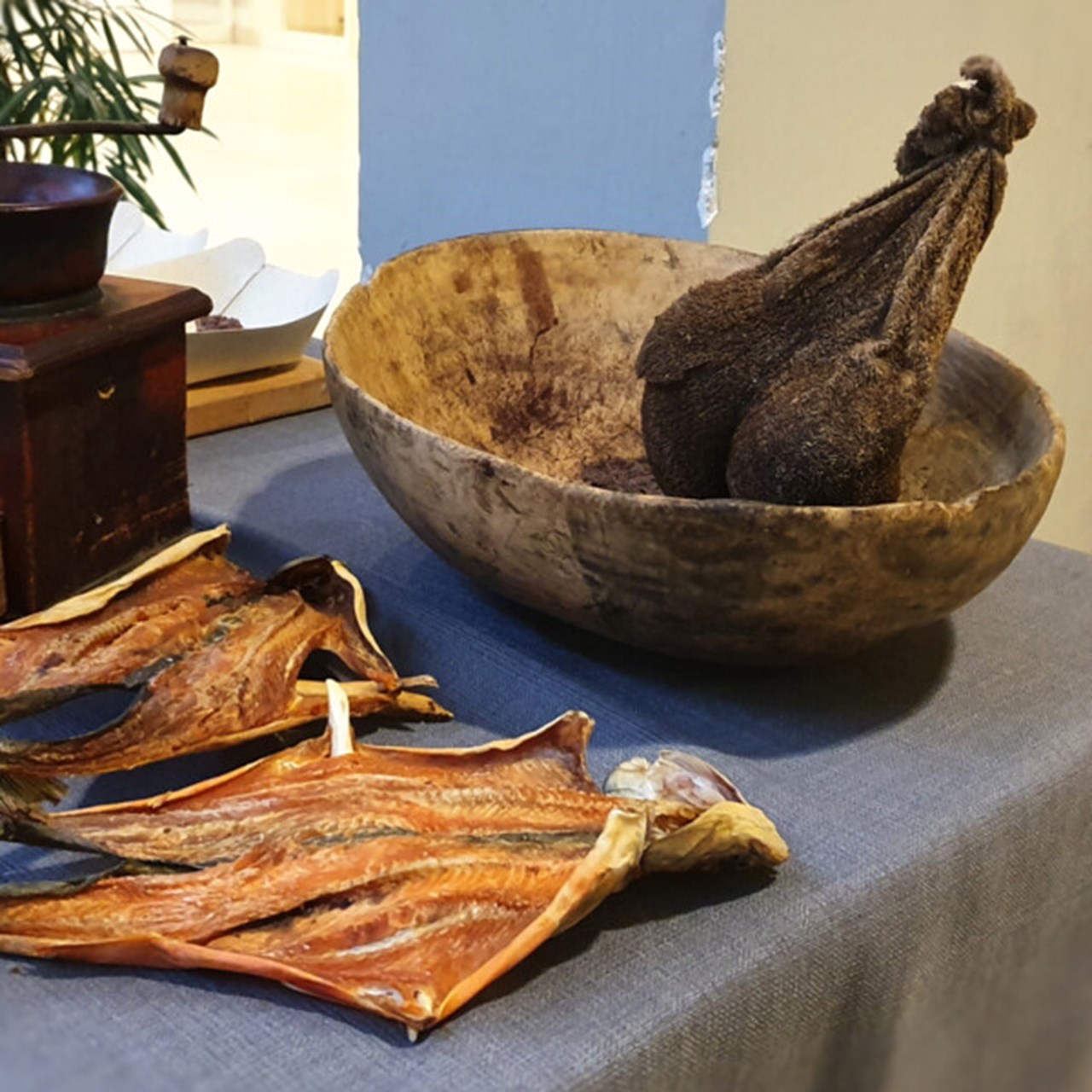 Bild på torkad fisk, en traditionell kaffekvarn och en torkad renmage
