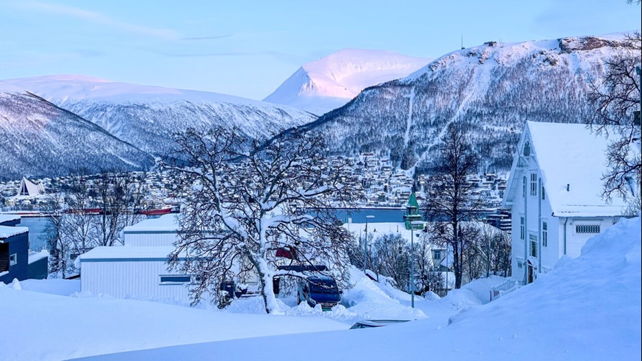 Snöig by och berg i Tromsö