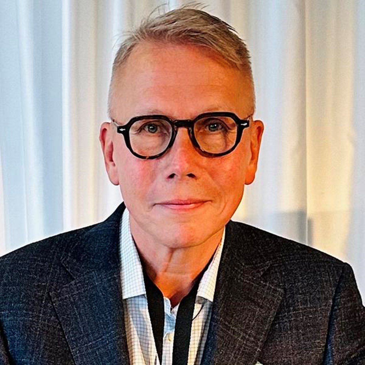 En kostymklädd man sitter vid ett bord.