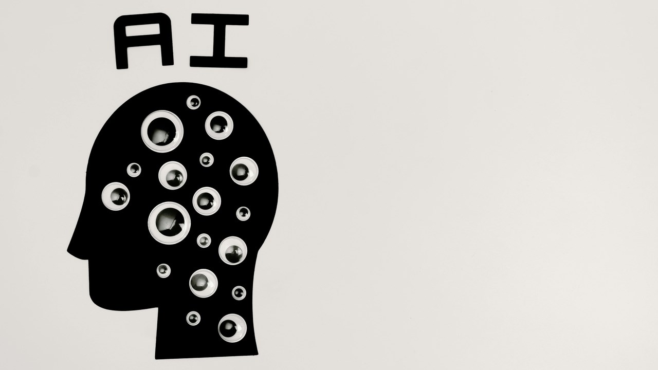 svartvit grafik föreställande ett huvud med ögon fästa och bokstäverna "AI"