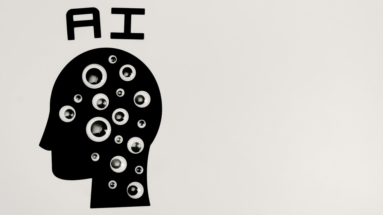 Graphics of a head with eyes on and the letters "AI" above it.
