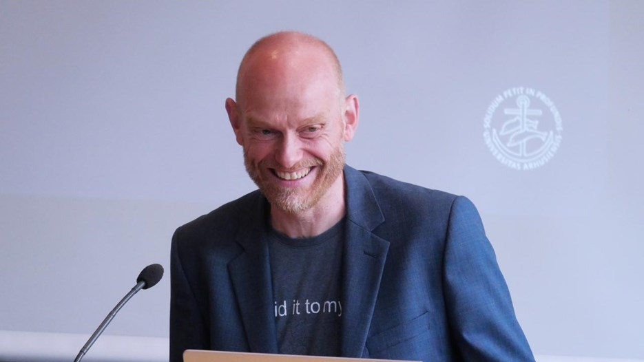 Mikkel Valentin står vid talarstolen.
