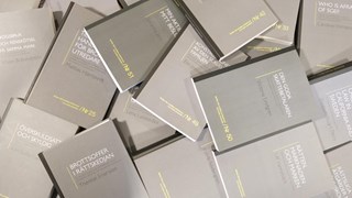 Avhandlingar utspridda över ett bord, fotat uppifrån.