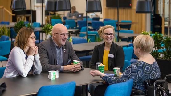 Deltagare i AIMday 2018 samtalar vid ett bord.