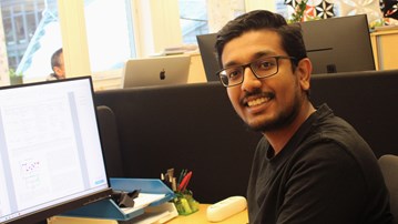 Foto av doktoranden Aswin Gopakumar som sitter vid sin arbetsplats