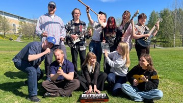 Musik 3 som poserar med instrument.