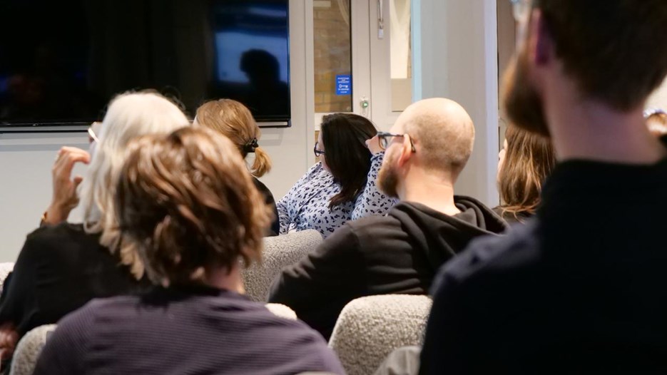 En grupp människor som sitter i ett rum och tittar på en presentation.