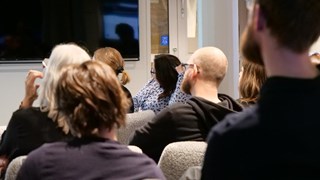 En grupp människor som sitter i ett rum och tittar på en presentation.