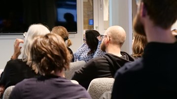 En grupp människor som sitter i ett rum och tittar på en presentation.
