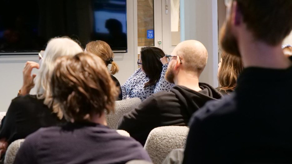 En grupp människor som sitter i ett rum och tittar på en presentation.