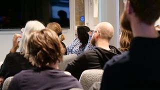 En grupp människor som sitter i ett rum och tittar på en presentation.