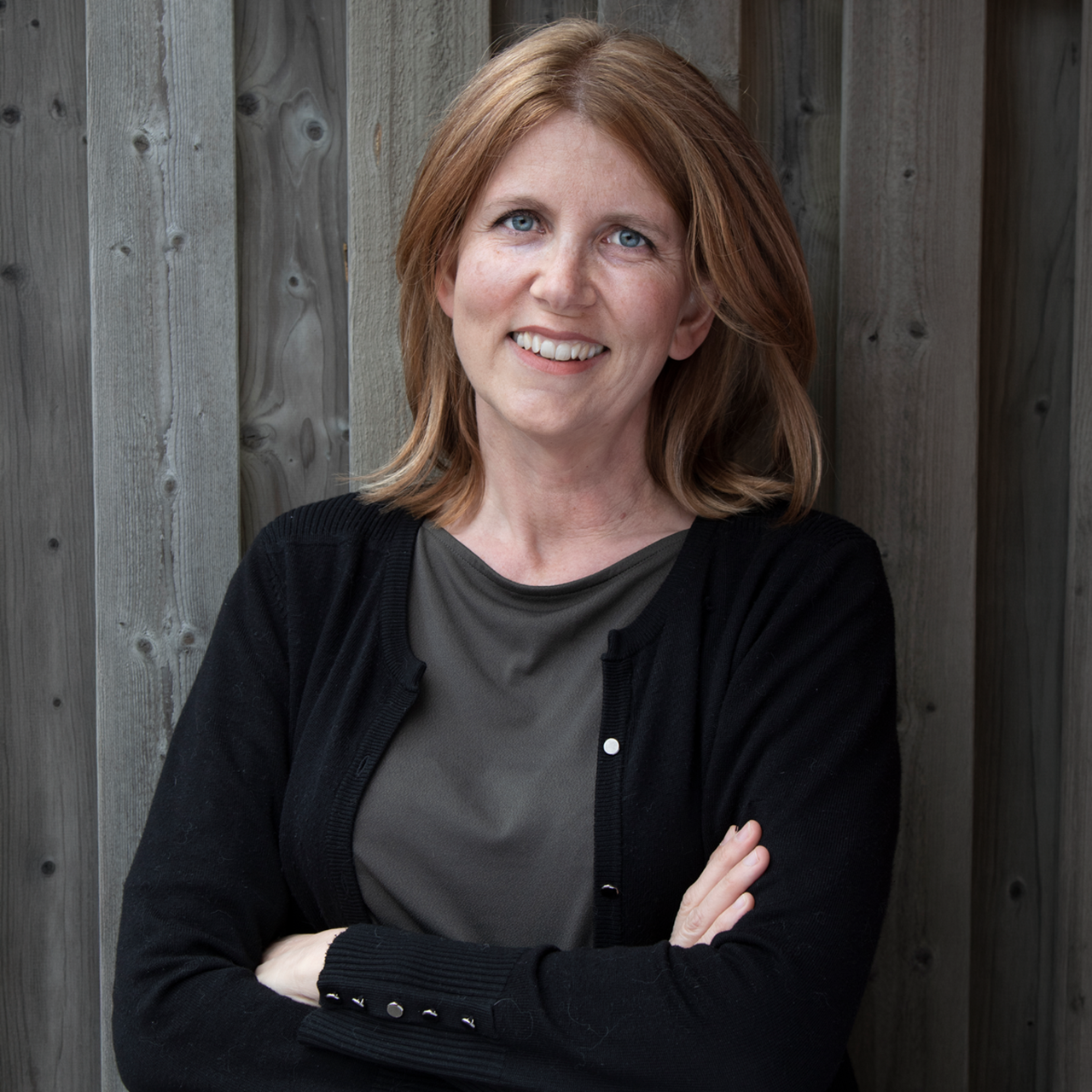 Sara Viklund står framför en trävägg.