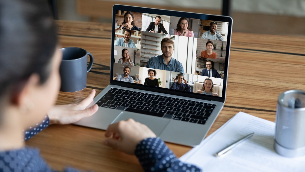 Person deltar i ett digitalt möte via skärmen på sin laptop.