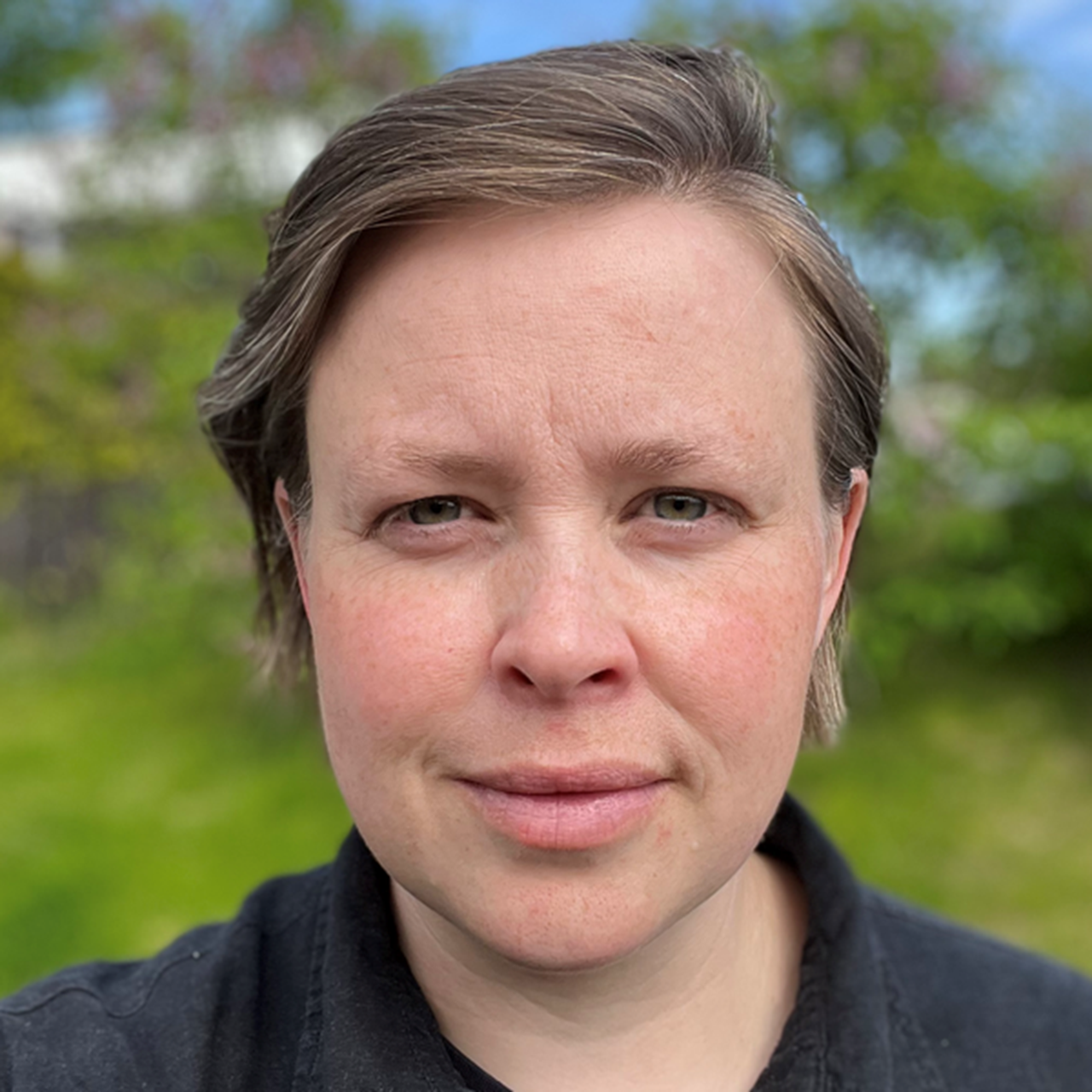 En kvinna i en svart tr&ouml;ja som poserar f&ouml;r en bild.