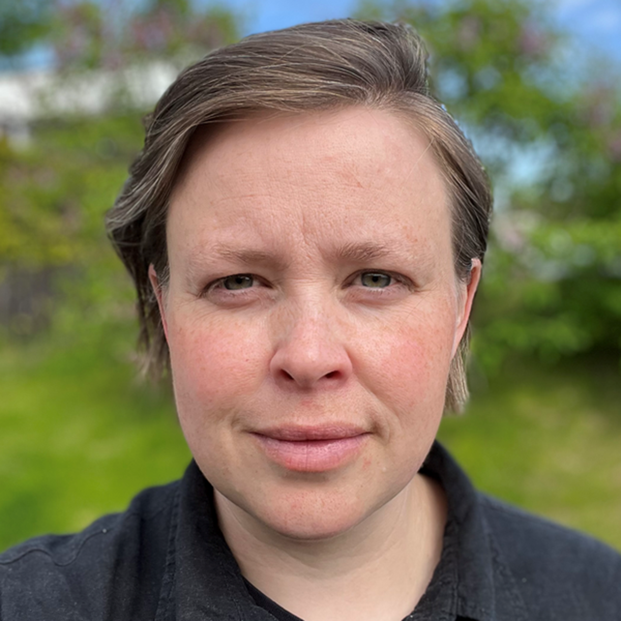 En kvinna i en svart tröja som poserar för en bild.