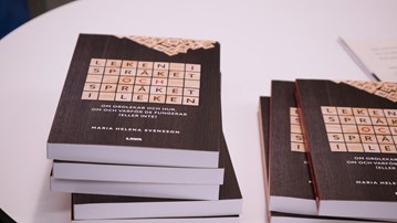 Boken Leken i språket och språket i leken ligger i två högar på ett bord.