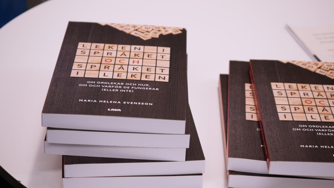 Boken Leken i spr&aring;ket och spr&aring;ket i leken ligger i tv&aring; h&ouml;gar p&aring; ett bord.
