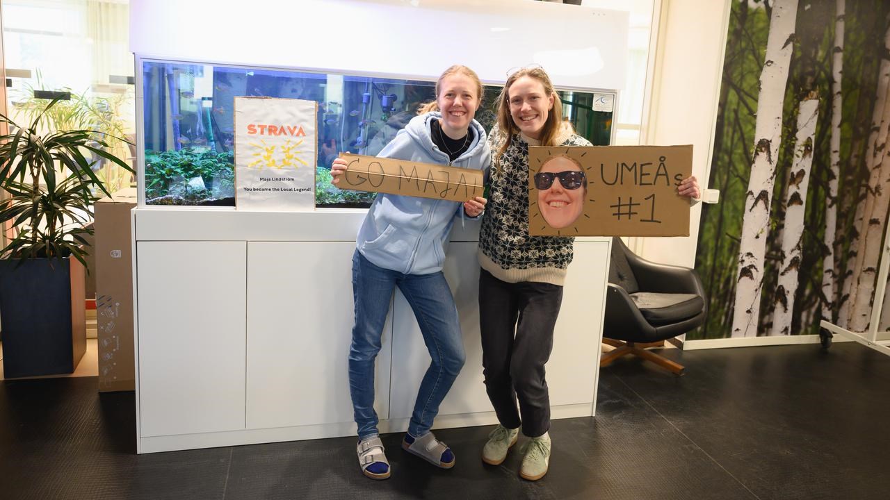 A couple of women standing next to each other holding signs.