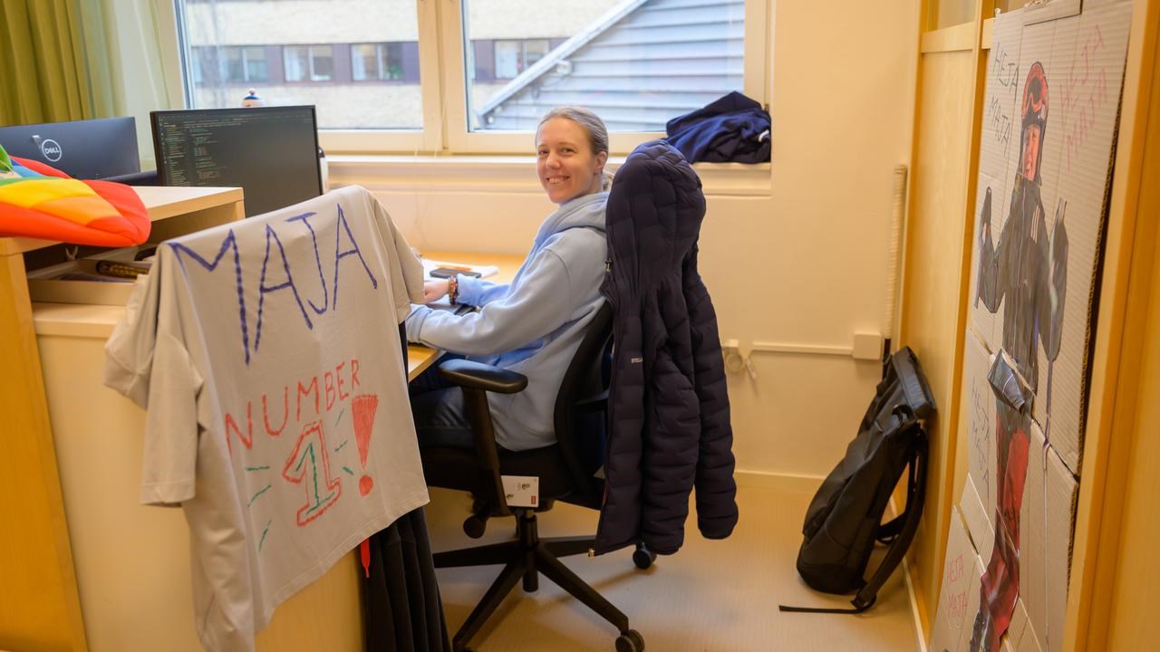 A woman sitting at a desk in front of a window.