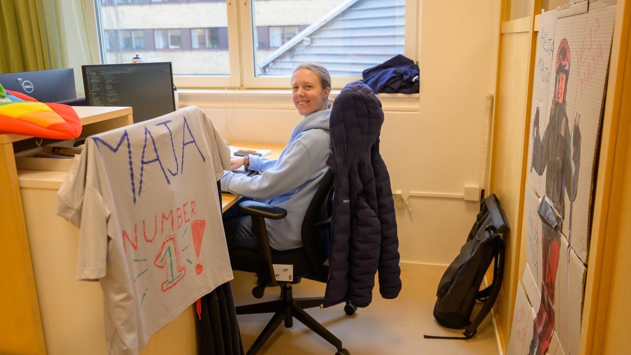 A woman sitting at a desk in front of a window.