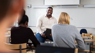 En grupp människor som sitter i ett klassrum.