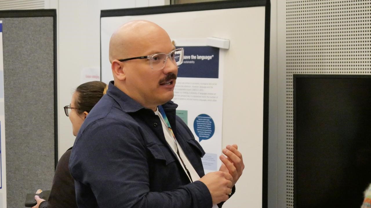 En man står framför en poster (poster session).