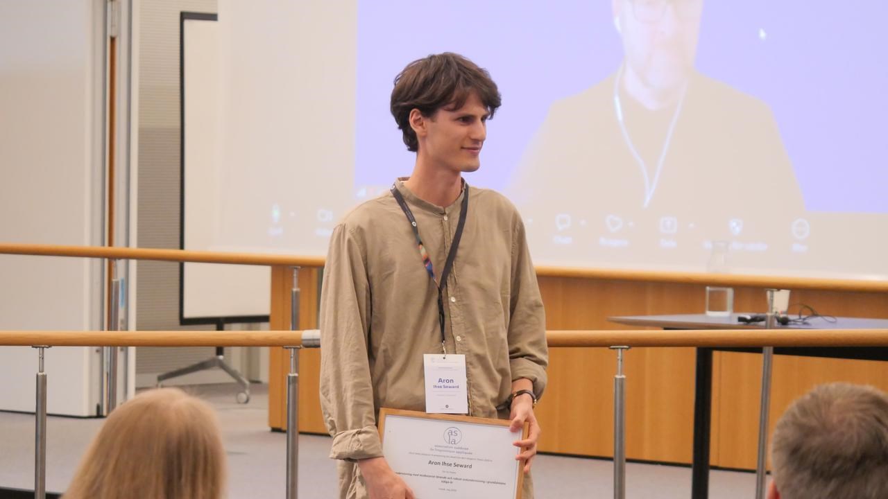 Aaron Ihse Seward tar emot pris för bästa studentuppsats.