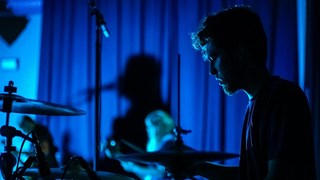 En man som spelar trummor i ett mörkt rum.