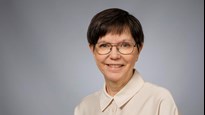 En kvinna med glasögon och vit skjorta