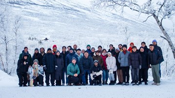 A group of people standing next to each other in the snow.