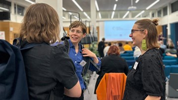 En grupp människor som pratar i en konferenslokal.