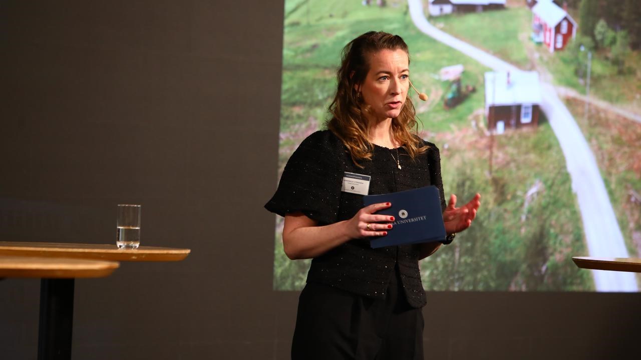 En kvinna står framför en projektorskärm.