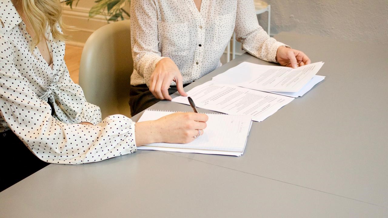Två kvinnor sitter och går igenom papper