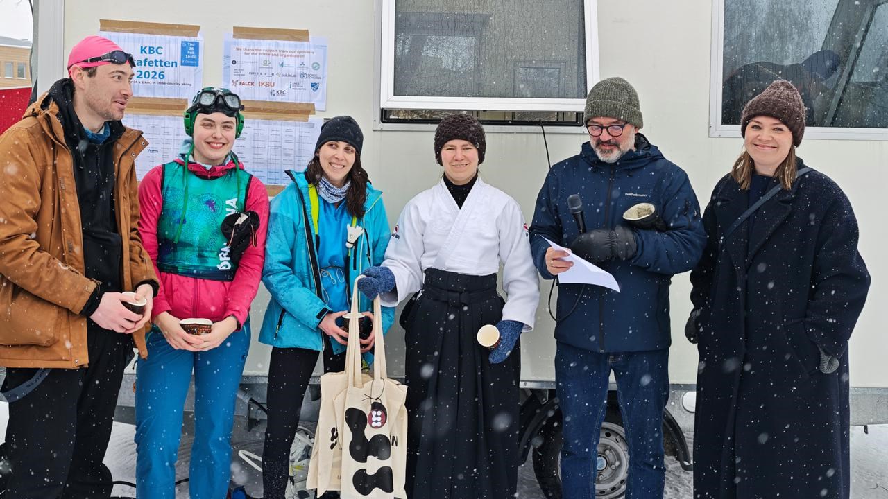 A group of people standing in front of a mobile secretarial van and receiving prizes.