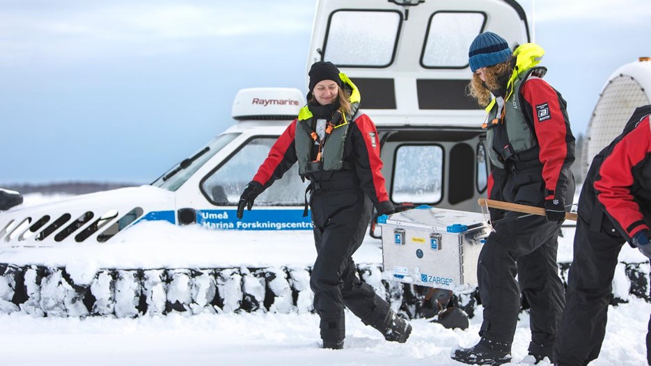 Personer som arbetar med provtagning på is med en svävare.