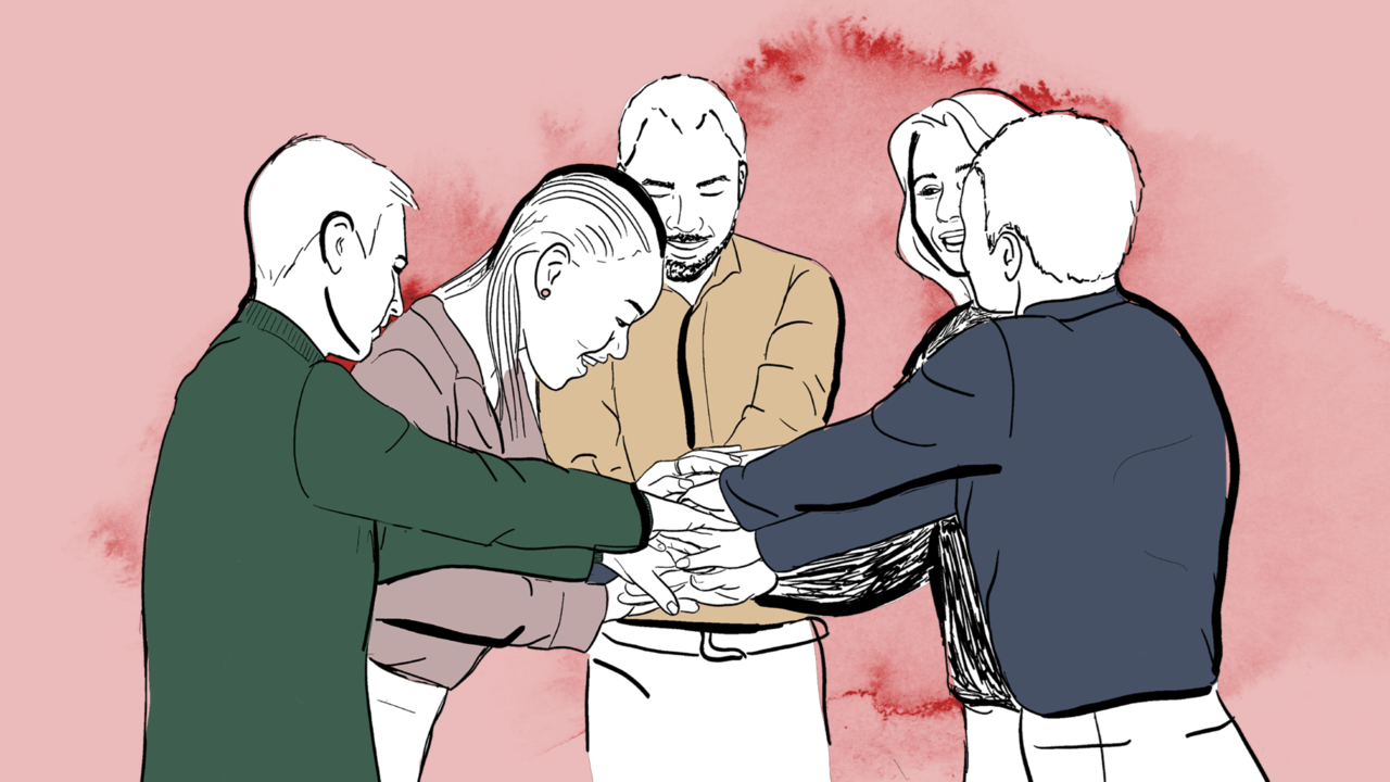 Grupp med människor som lagt sina händer på varandra