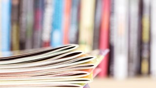 A pile of publications on a desk.