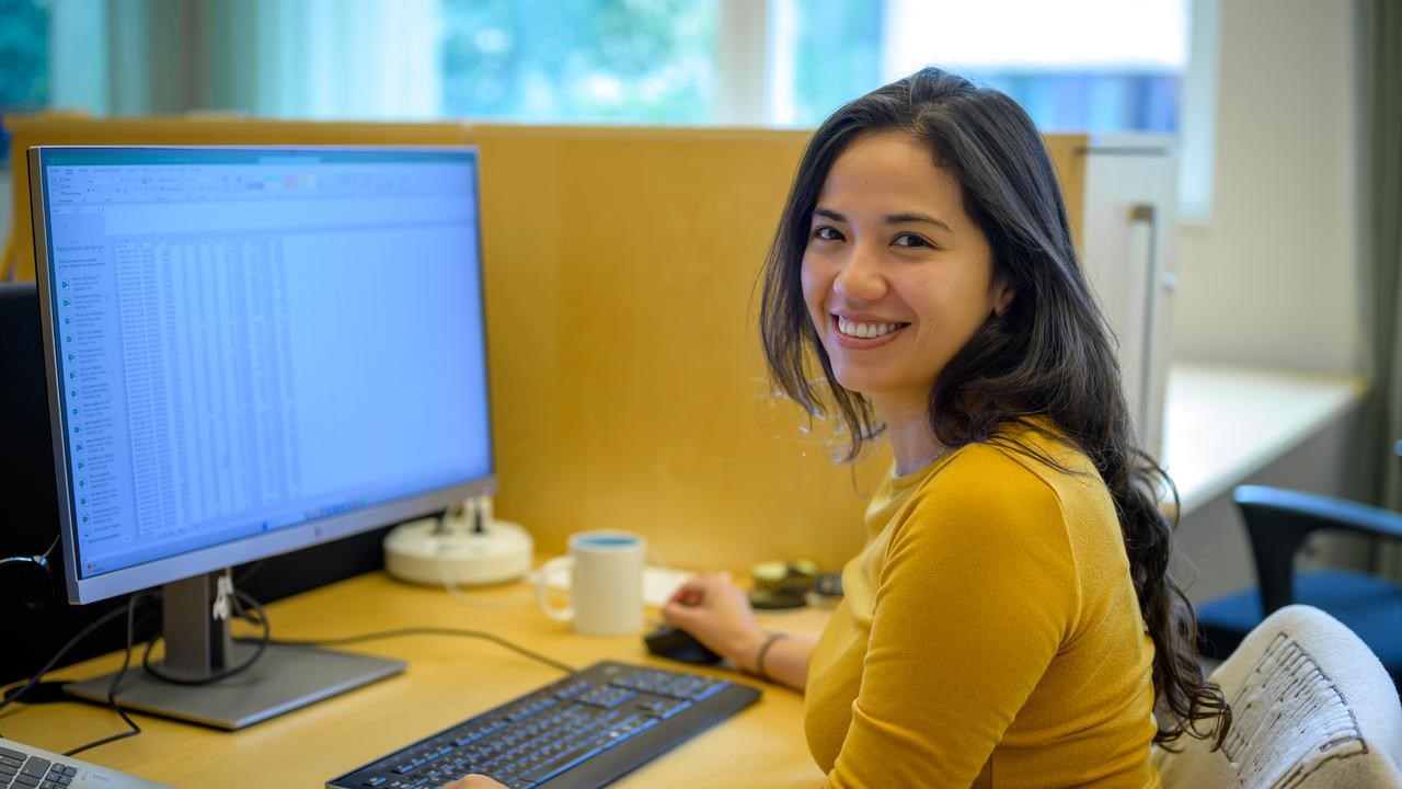 A woman sitting at a desk in front of a computer.