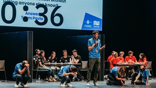 Students answering questions on a stage in Coimbra.