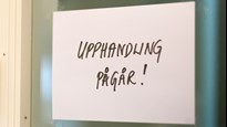 Textad skylt med ordet "Upphandling pågår" uppsatt vid en dörr.