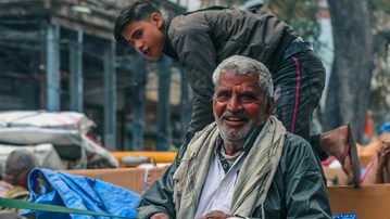 En man som sitter på en hästdragen vagn.