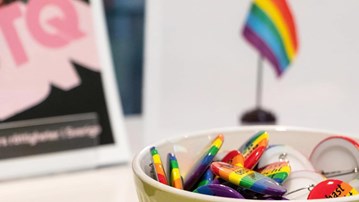En skål med regnbågsfärgade Pride-pins. 