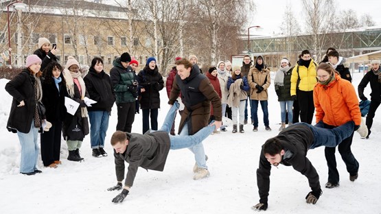 students playing in the snow on campus