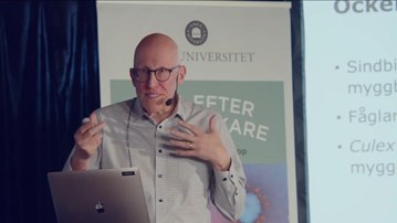 En man som står framför en bärbar dator.