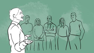 En kvinna som pratar inför en grupp människor.