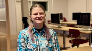 Bild på Ester Olofsson i dörröppningen till en datasal.